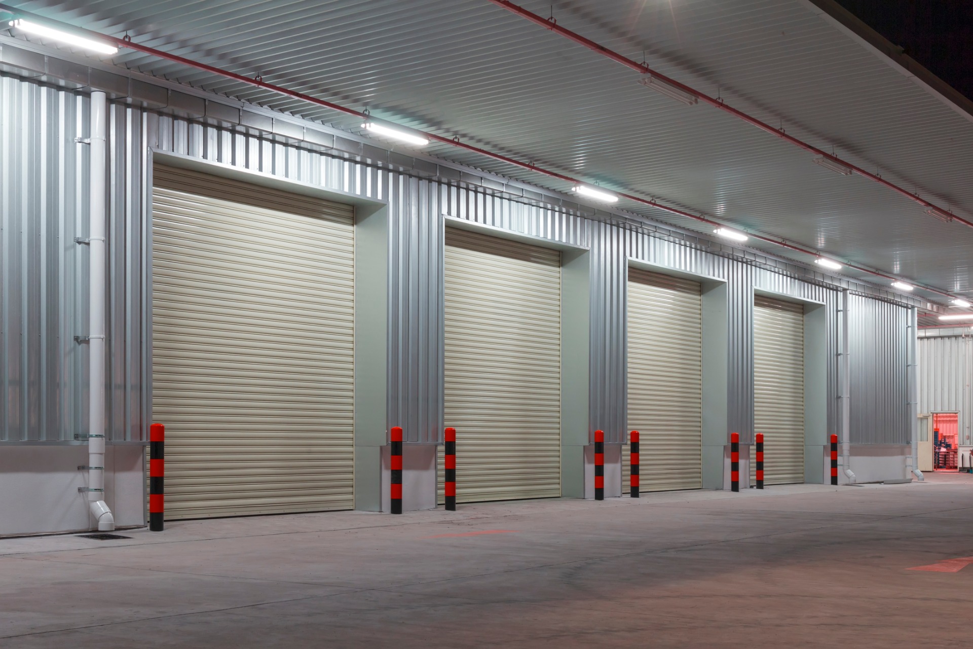 Five shutter doors, with 2 rows of 3 glass panes, installed on warehouse building