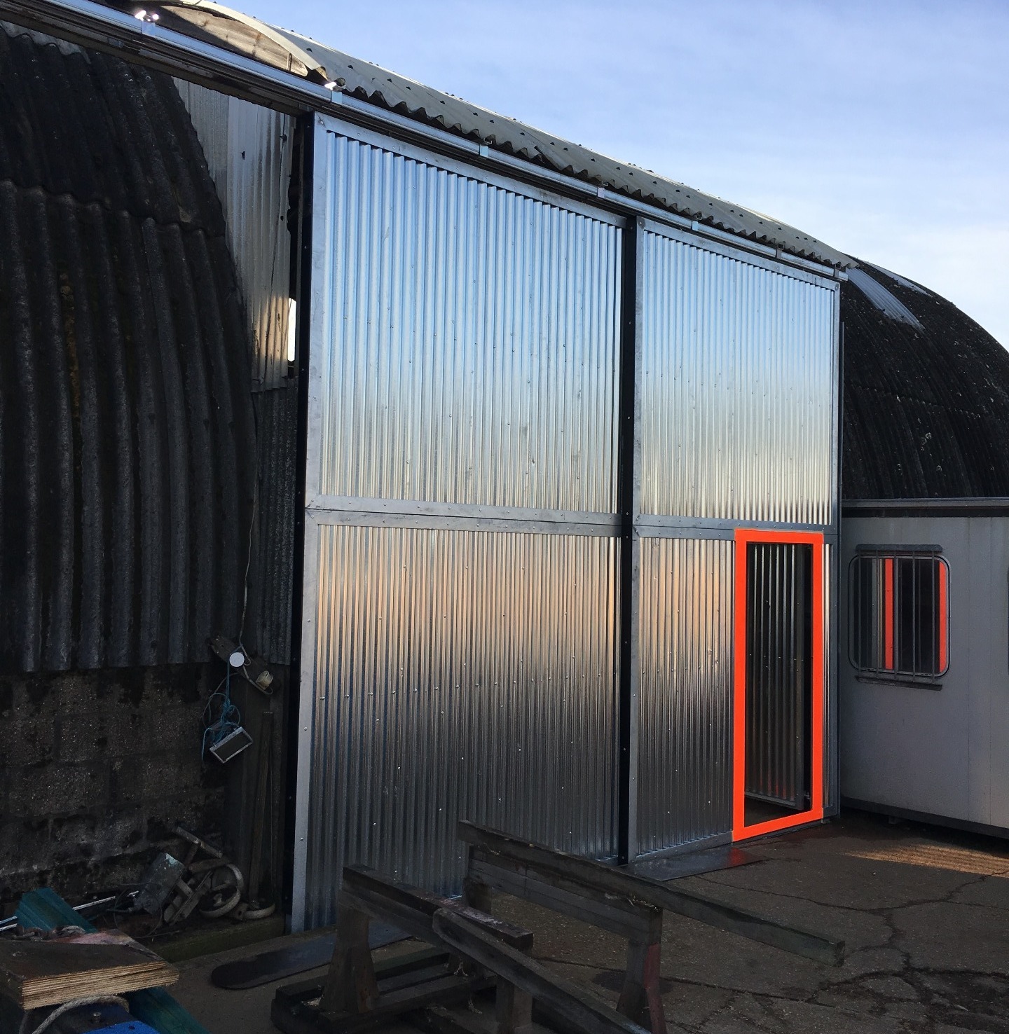 Metal sheet walls with an orange rimmed door for easy access