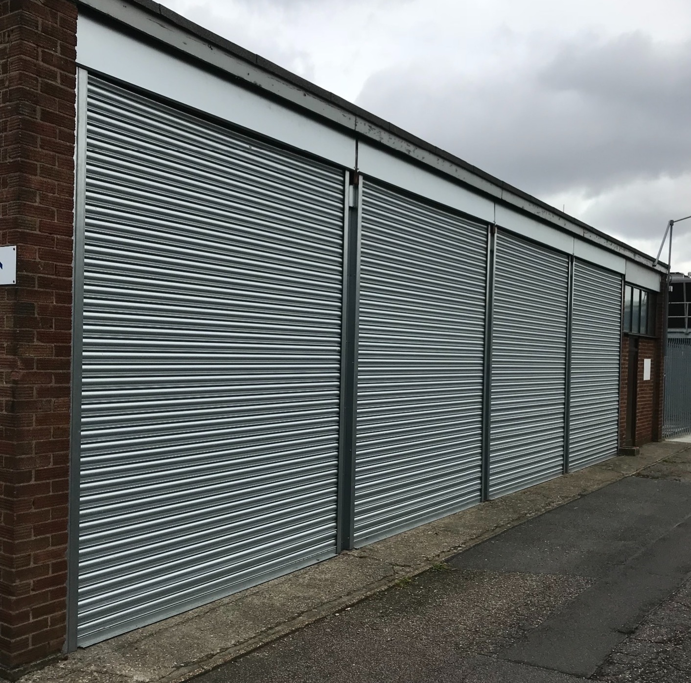 Industrial Roller shutter door installed on small building within an outdoor work area with outdoor work area